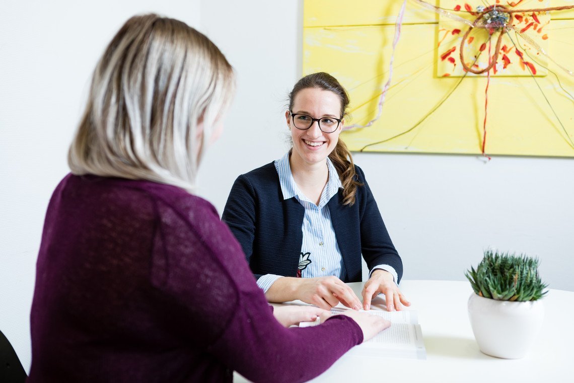 Zwei Frauen in einem Gespräch am Tisch